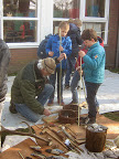 Pijlpunten maken met leerlingen van de basisschool. Luxe hulp voor de "Verteller van het Oude", Ernest Mols, Nederlands kampioen vuistbijlen maken.